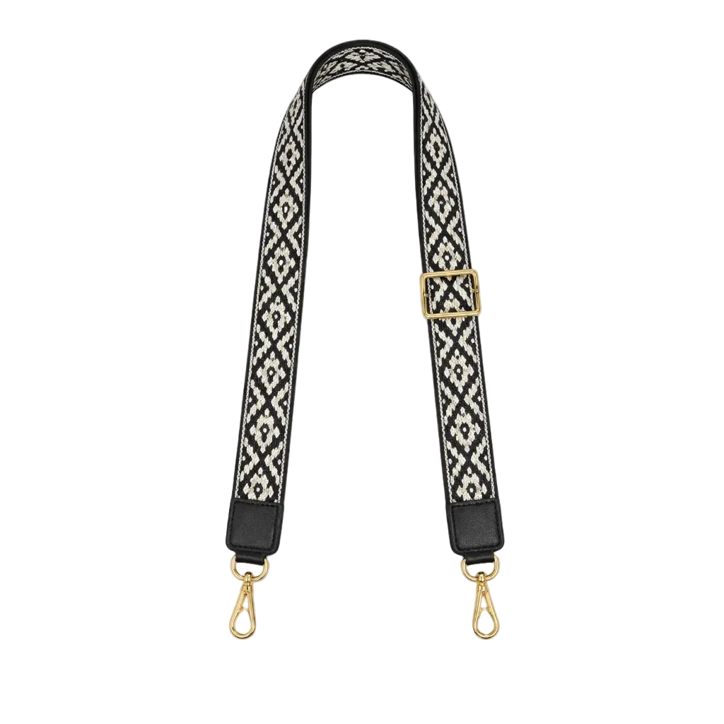 Black and white patterned bag strap with gold hardware on a white background