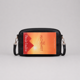 The Daily Black bookmark-inspired crossbody bag holding a book