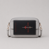 The Daily Stone bookmark-inspired crossbody bag holding a book