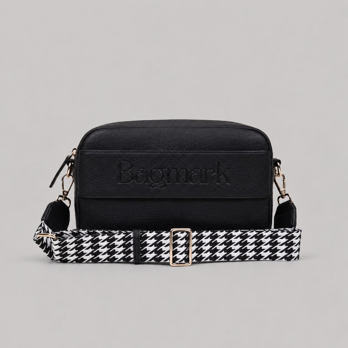 The Daily in Black bookmark crossbody bag with a patterned webbing strap