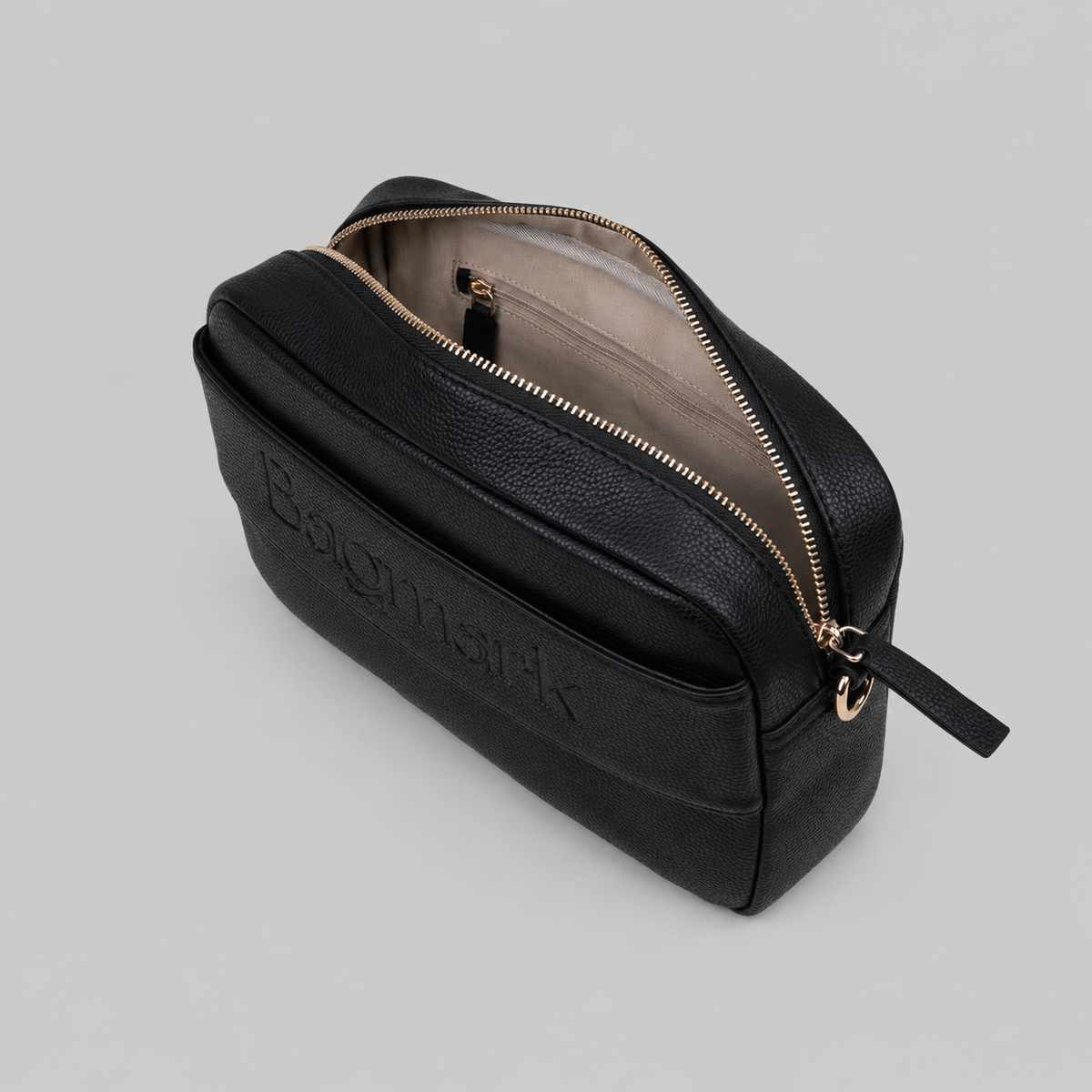 The Daily in Black bookmark-inspired crossbody bag with gold zipper displaying inner compartments of the leather bag