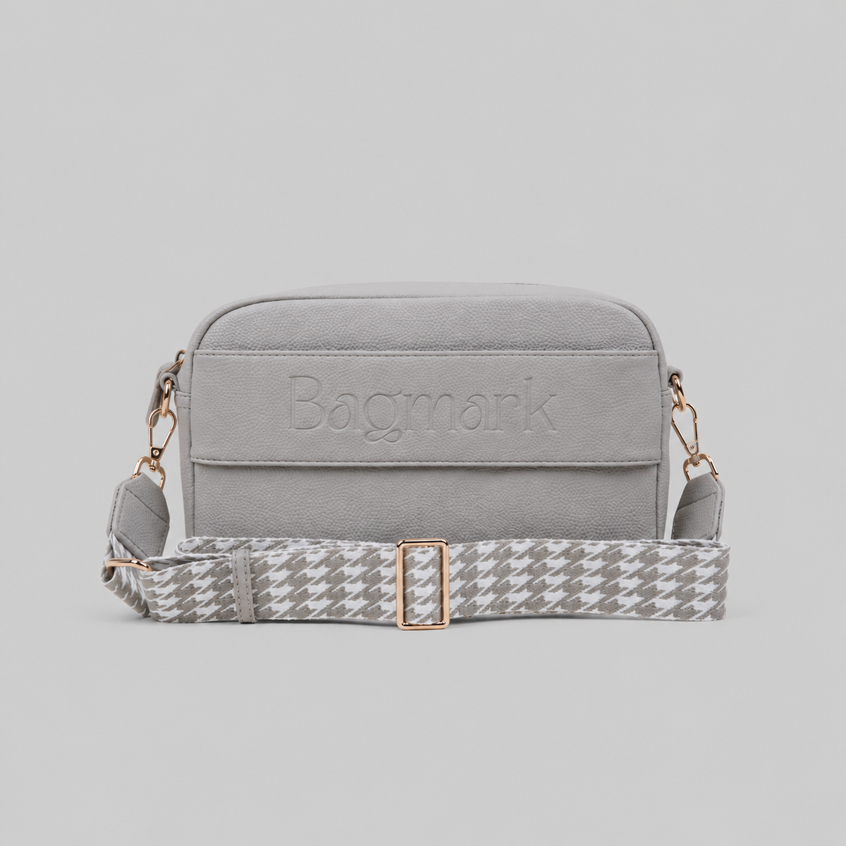 The Daily in Stone bookmark crossbody bag with a patterned webbing strap