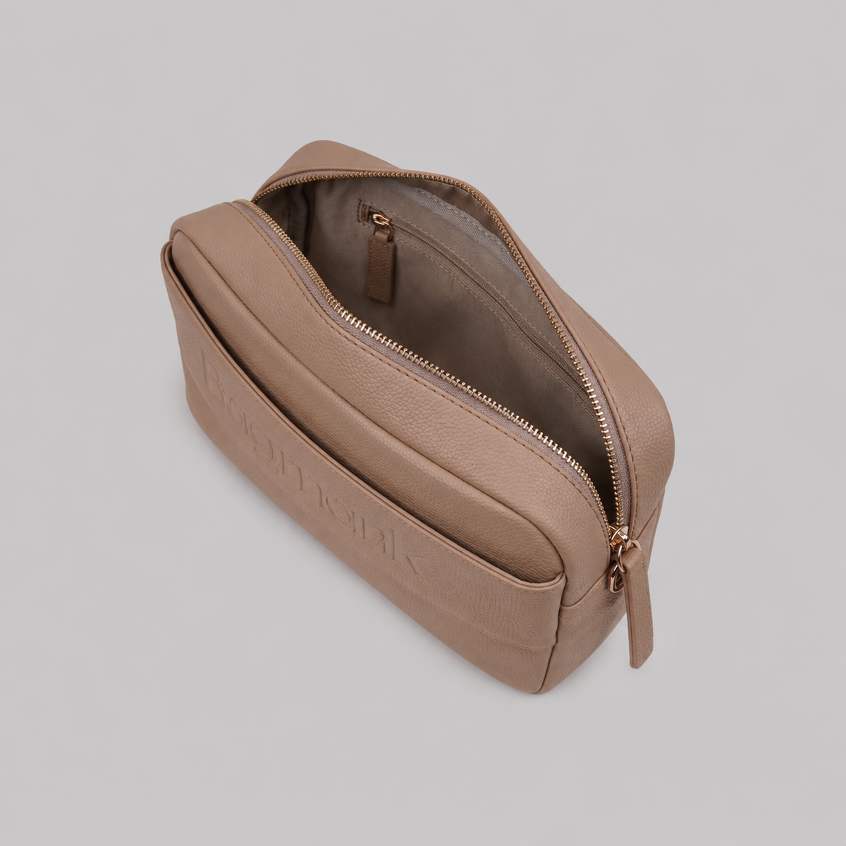 The Daily in Camel bookmark-inspired crossbody bag with gold zipper displaying inner compartments of the bag