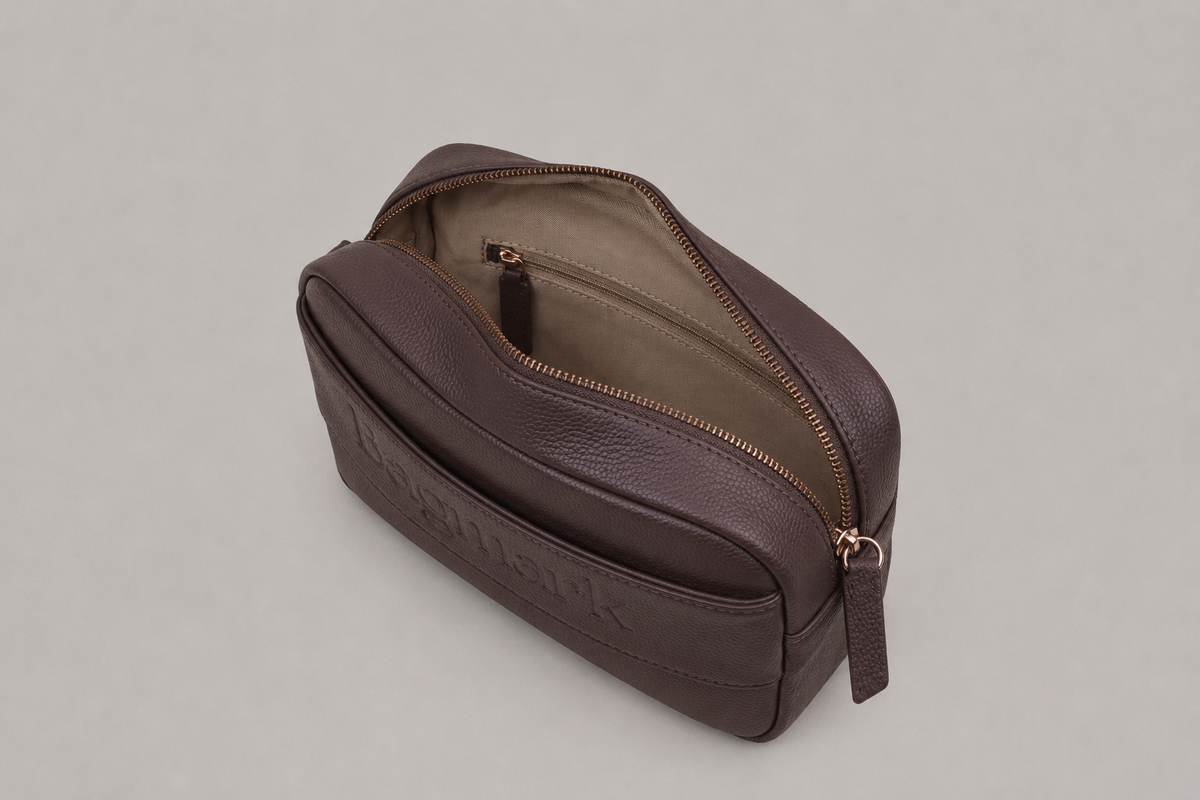 The Daily in Taupe Brown bookmark-inspired crossbody bag with gold zipper displaying inner compartments of the bag