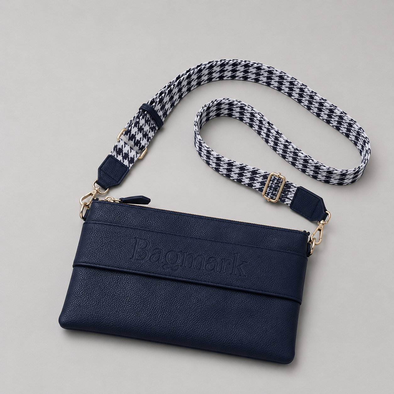 The Essential Navy bookmark crossbody bag with a patterned webbing strap