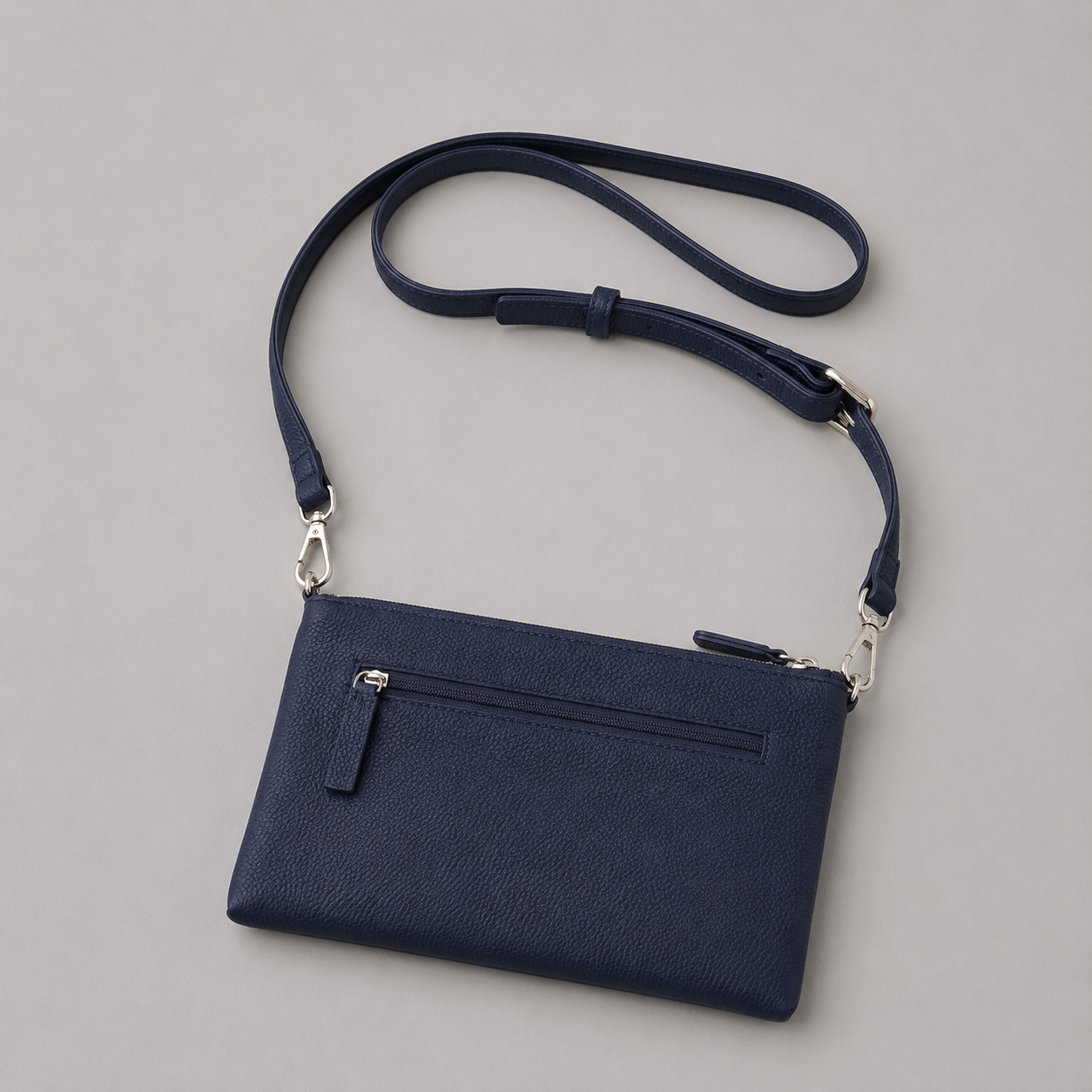 The Essential Navy literary bag displaying back zip pocket