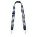 Navy and white houndstooth patterned strap with gold hardware on a white background