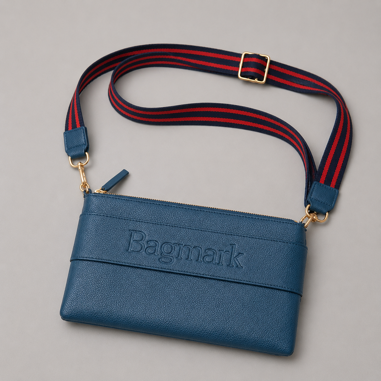 The Essential Teal bookmark crossbody bag with a striped webbing strap