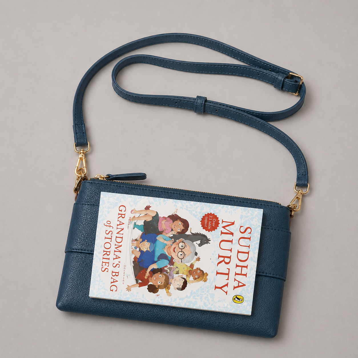The Essential Teal bookmark-inspired crossbody bag holding a book