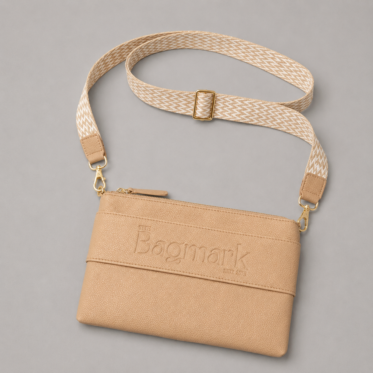 The Essential Camel bookmark crossbody bag with a patterned webbing strap
