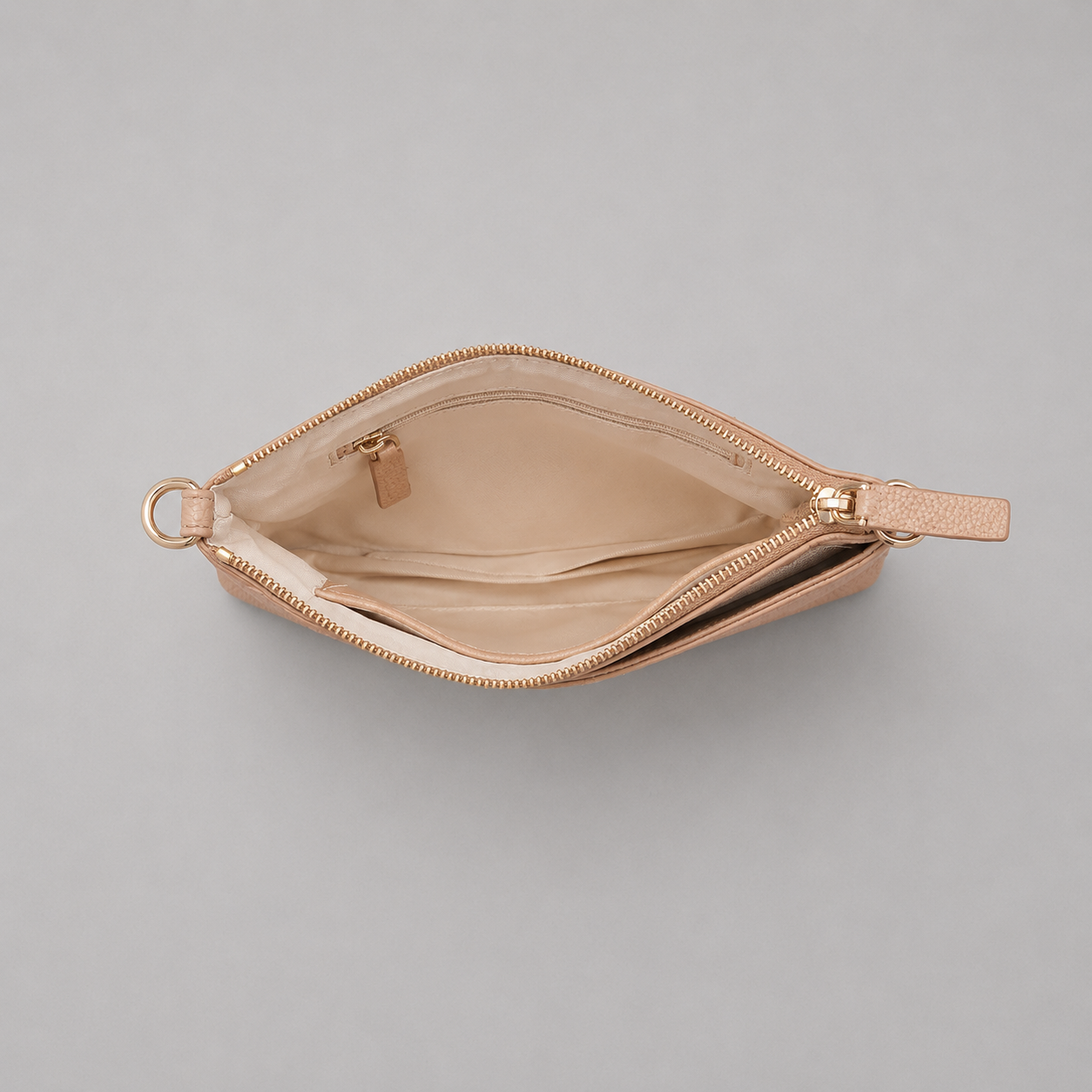 The Essential Camel bookmark-inspired crossbody bag with gold zipper displaying inner compartments of the bag