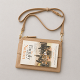 The Essential Camel bookmark-inspired crossbody bag holding a book